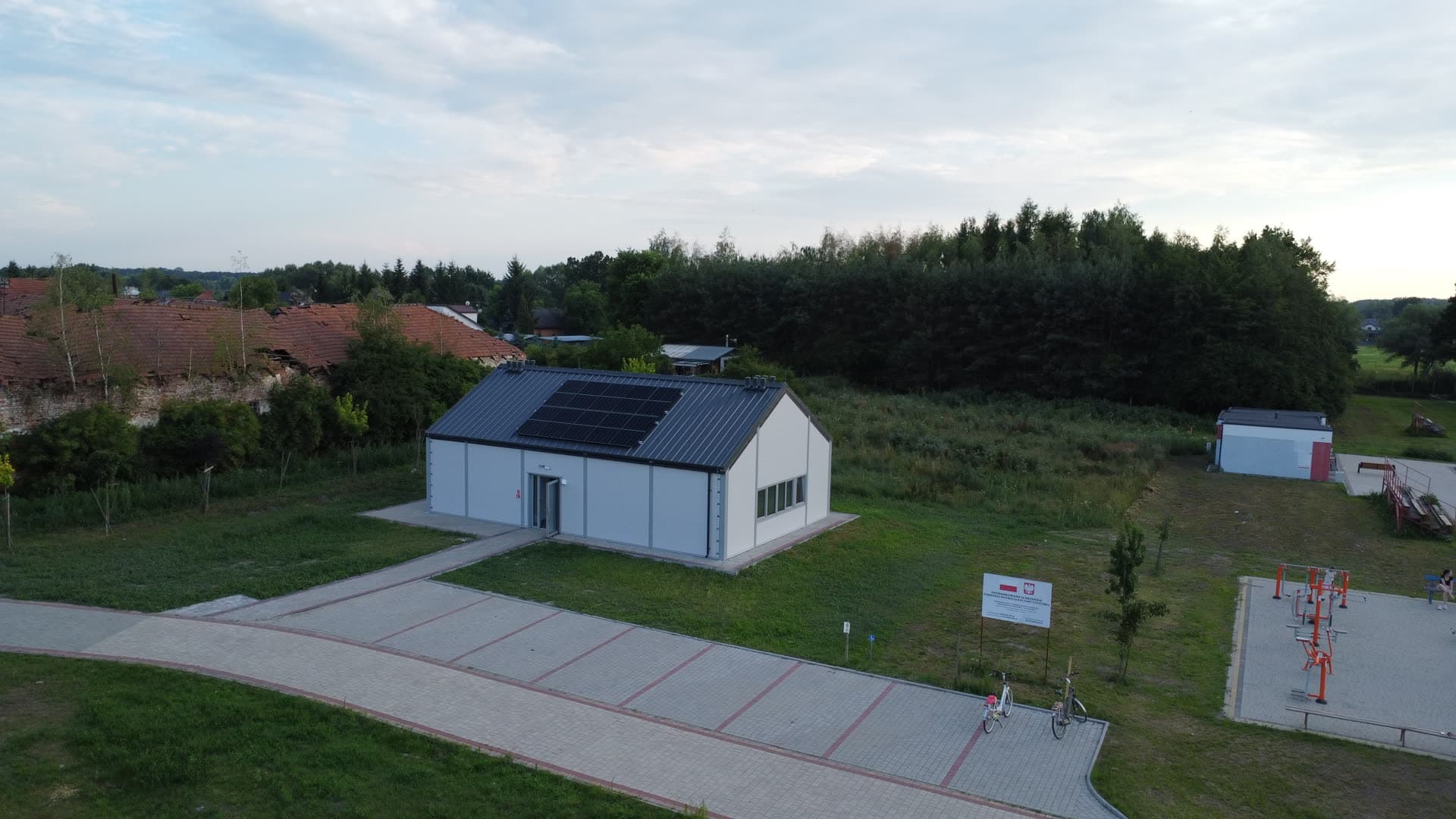 Szerokie ujęcie z drona: hala, ciągi piesze i plac zabaw